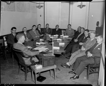 Men in suits at a meeting with visual aids