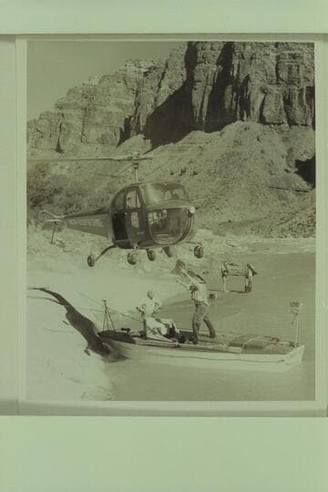 Red Carson piloting the helicopter over the "Esmeralda" at the head of Hance Rapid. Joe Desloge and Ed Hudson are in the boat. Marston and Taylor in the background