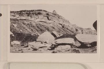 Looking north from a point on the San Juan across from Zahn's Camp. Moencopie with the De Chelly sandstone lentil in foreground. Shinarump forms high point. Note name of Paul Zahn painted on the boulder at center