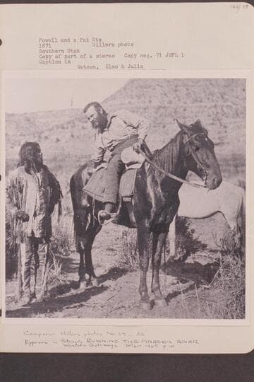 Powell and a Pai Ute. Southern Utah. Copy of part of a stereo with caption: "Watson, Elmo & Julia." Major Powell inquires way to a water hole near the Grand Canyon